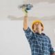 Homme avec casque de construction jaune applicant du plâtre au plafond Plâtrage 5286